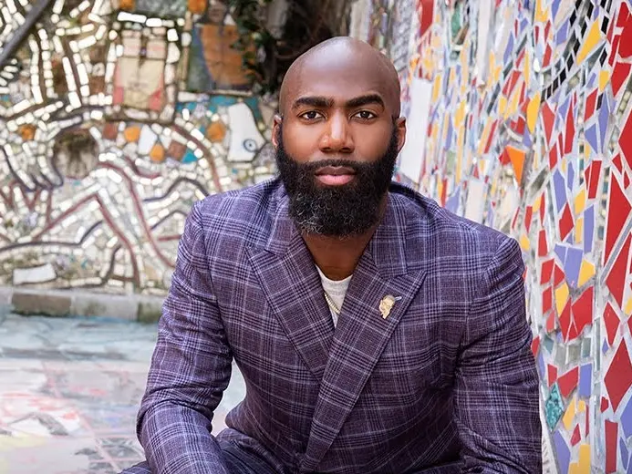 Malcom Jenkins, a bald Black man, wears a blue checked suit